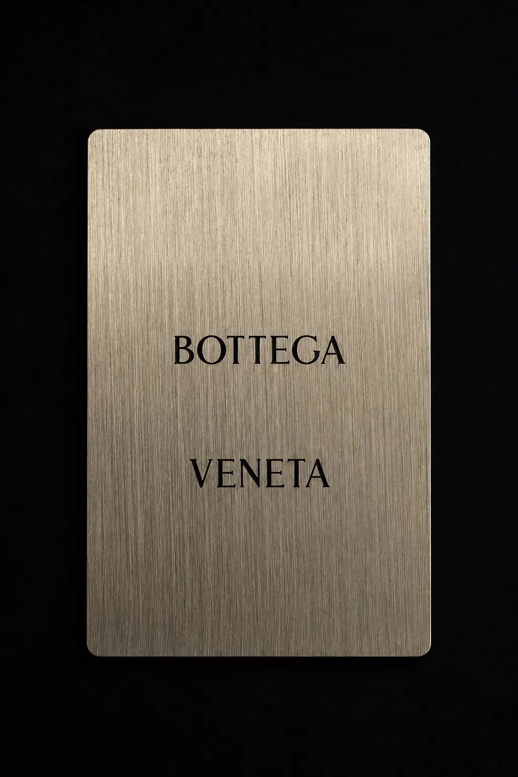 Front of a champagne-tone Bottega Veneta connected metal card